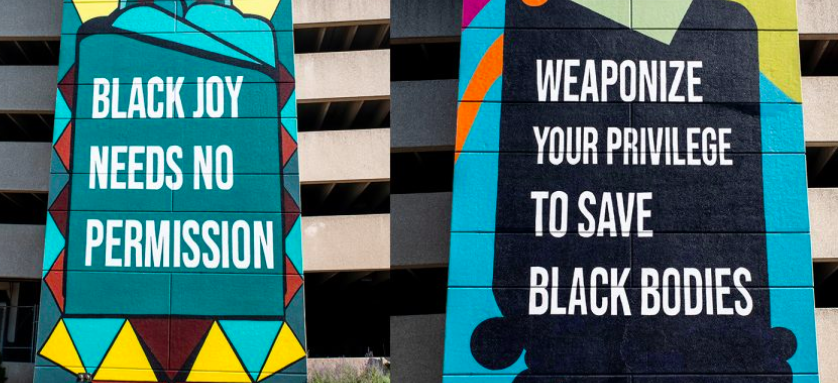 Two wall murals. One says Black Joy Needs No Permissions, the other reads Weaponize Your Privilege to Save Black Bodies 