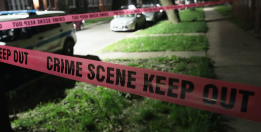 Red crime scene tape in a dark backyard