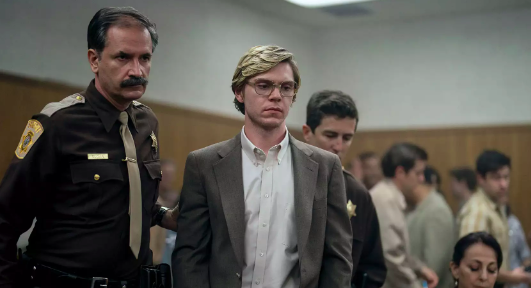 Screencap from Netflix Series Dahmer, with Dahmer being led by cop