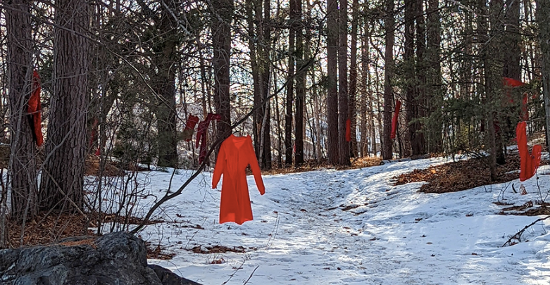 Red shirts hanging in snowy forest