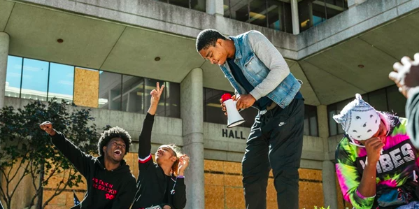 Group of young Black individuals hanging out, havin gfun