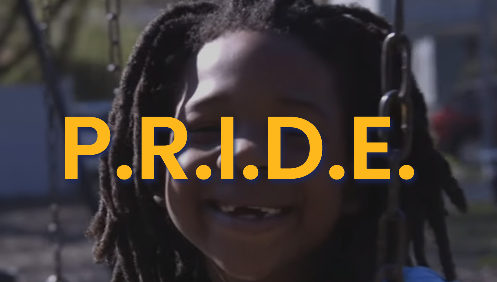 The word PRIDE overlaid on top of a picture of a smiling black child