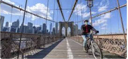 Bicyclist wearing a mask on a bridge