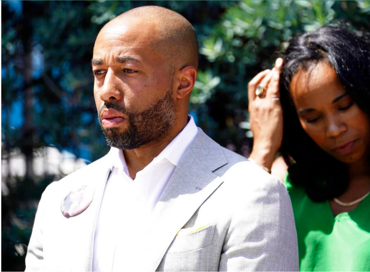 Charles Johnson wears a button with a picture of his wife, Kira, during a press conference announcing a lawsuit outside Cedars-Sinai Medical Center, Wednesday in Los Angeles. Kira Johnson died at the hospital in 2016 from complications after giving birth by cesarean section.