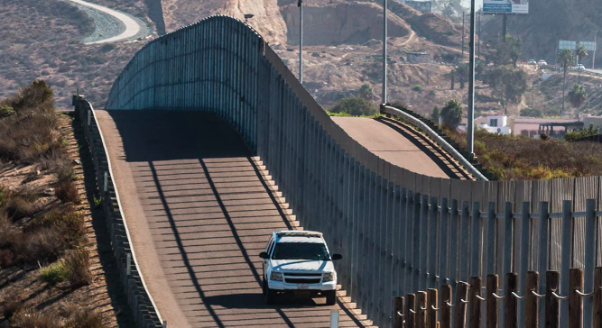 Truck drives next to the Mexican/US border