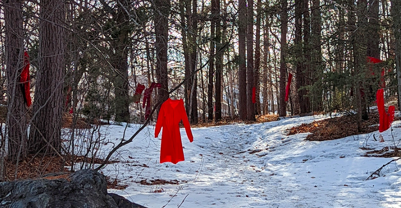 Red shirts hanging in snowy forest