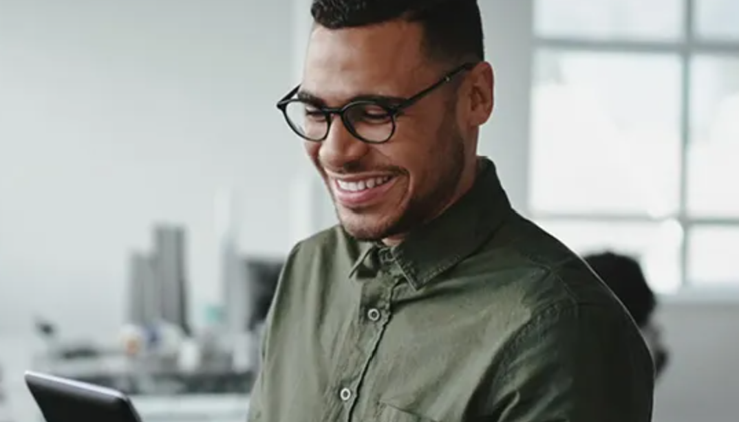 Man smiling at tablet